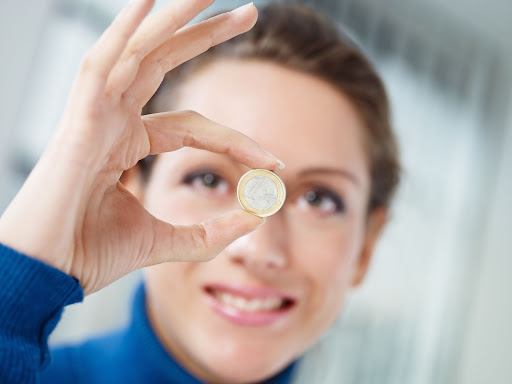 Femme qui tient une pièce d’1 euro