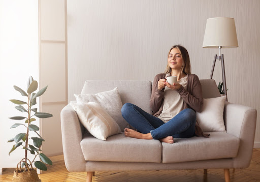 Femme sur un canapé, au chaud en intérieur 